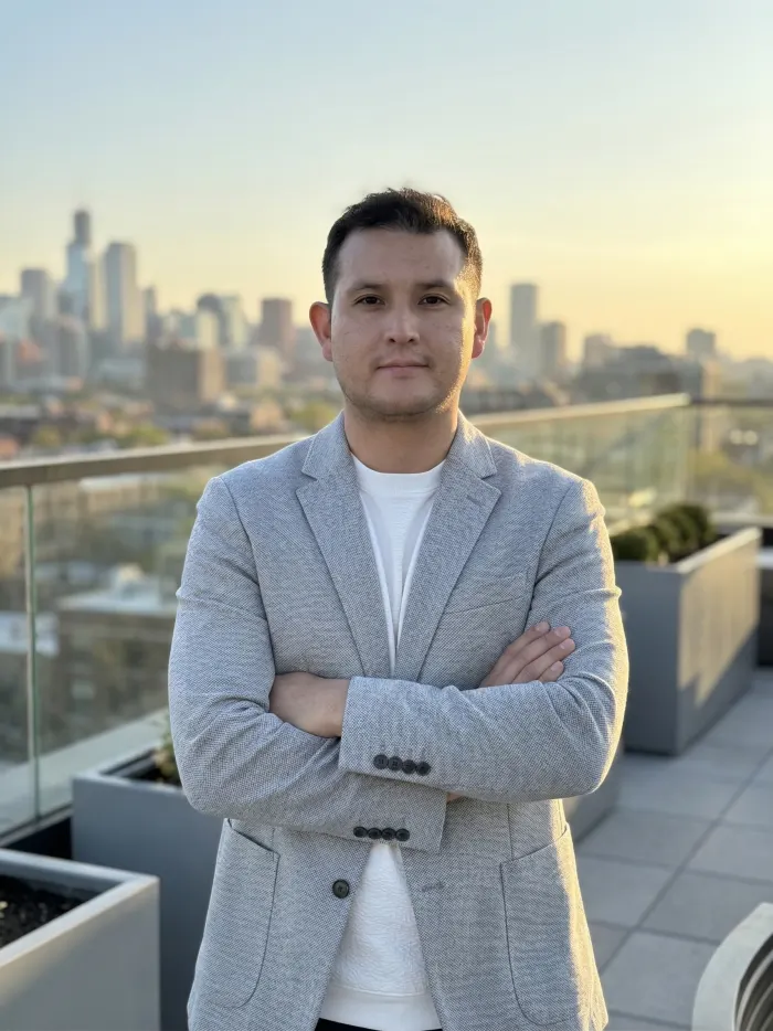 Dennis Alejo on a rooftop terrace with a city skyline